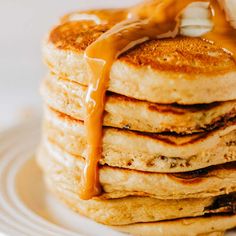 a stack of pancakes covered in syrup and drizzled with caramel sauce