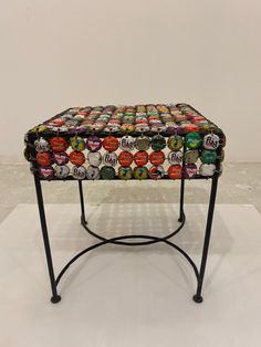 a table made out of beer cans on top of a white surface with black legs