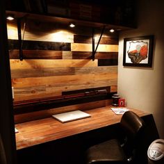 a desk with a laptop on it in front of a wood paneled office wall