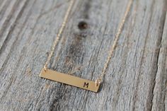 "Gold Bar Necklace - Personalized - 14K Gold Filled This gold name plate bar necklace can be personalized any number of ways. From 1 initial to full names or dates, the possibilities are endless! DETAILS: - All components are 14K Gold Filled. - Gold bar pendant is 1.25\" long and .25\" wide. - Offered in 3 different alignments - right (as pictured), left, or centered. - Choose length and number of letters/symbols from the drop-down menus. - Choose font from last photo. - Length is measured from Gold Nameplate Bar Necklace, Customizable Gold Nameplate Bar Necklace, Gold Bar Necklace With Nameplate, Customizable Gold Bar Necklace For Anniversary, Gold Hand Stamped Nameplate Necklace, Personalized Gold Bar Necklace With Name, Customizable Gold Bar Necklace For Personalized Gift, Minimalist Gold Bar Necklace With Name, Gold Rectangular Bar Necklace With Name