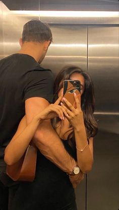 a man and woman taking a selfie in an elevator