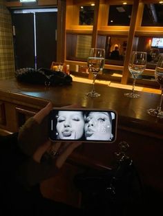 a person holding up a cell phone to take a selfie with two women on the screen