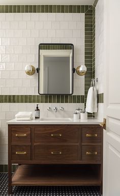 a bathroom with a sink, mirror and towel rack on the counter top in front of it