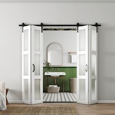 an open door leading to a green tiled bathroom