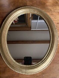 a round mirror sitting on top of a wooden table