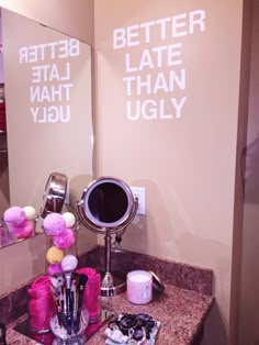 a bathroom sink with two mirrors and pink decorations on the counter top in front of it