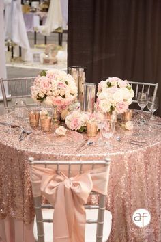 the table is set with pink and white flowers, champagne glasses, and silverware