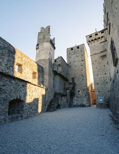 an alley way between two buildings with stone walls