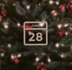 a calendar with the date 28 on it in front of a christmas tree