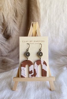 wooden earrings with white and brown paint on them