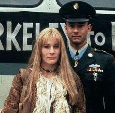 a man in uniform standing next to a blonde haired woman on the side of a bus