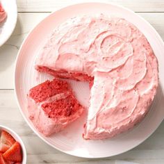 a piece of cake on a plate with strawberries and other desserts around it