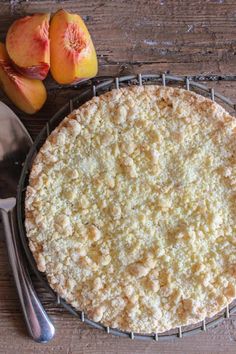 a pie sitting on top of a metal rack next to two pieces of peaches