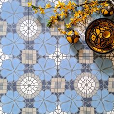 a blue and white tiled floor with yellow flowers