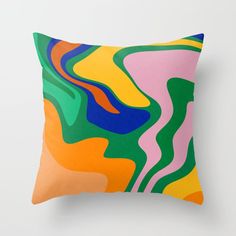 a colorful pillow with an abstract design on the front and back side, sitting against a white wall