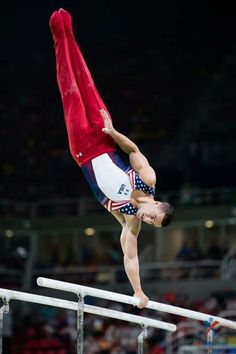 a man doing a handstand on top of a pole