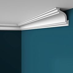 the corner of a room with blue walls and white molding on the wall above it