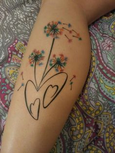 a woman's legs with tattoos on them and flowers in the middle of her leg