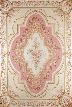 a pink and gold rug with floral designs on the center, in an ornate frame