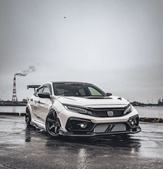 a white car parked in front of a body of water