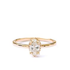 a yellow gold ring with an oval cut diamond in the center, on a white background