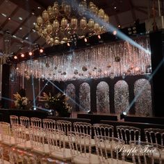 a large room with rows of chairs and chandeliers