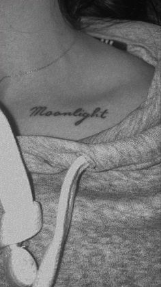 a woman with a tattoo on her shoulder that reads moonlightlight and is holding a stuffed animal