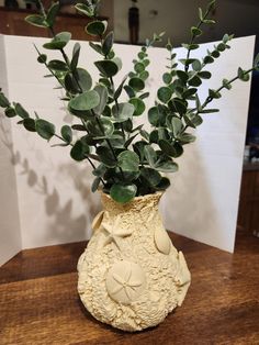 a vase with some green plants in it