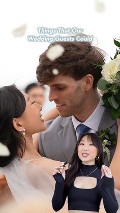 a man and woman standing next to each other in front of a crowd with flowers