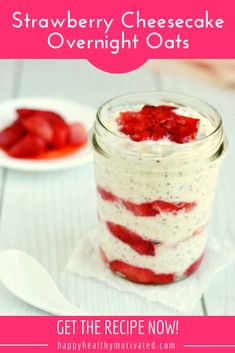 a jar filled with yogurt and strawberries next to a spoon