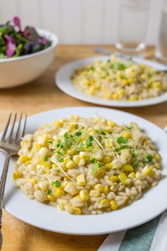 a white plate topped with rice covered in corn and garnish next to a fork