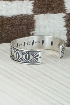 This sterling silver bracelet was made by Navajo silversmith Calvin Martinez. The inside is signed C MTZ, Navajo and stamped sterling.Size: 5 3/8" (will fit up to a 6 3/8" wrist)Gap: 1"Width: 5/8"Free shipping on all orders! We ship with USPS and always include tracking. All orders ship within a day of payment.Returns are accepted up to 30 days after you receive your order. Just send us a message. Our shop offers cash back or store credit. The item must be returned in new condition. Southwestern Style Etched Sterling Silver Bracelet, Artisan Sterling Silver Bracelet With Inlay, Southwestern Sterling Silver Stamped Bangle Bracelet, Southwestern Style Stamped Sterling Silver Bangle Bracelet, Southwestern Style Stamped Sterling Silver Bangle, Sterling Silver Southwestern Bracelet, Southwestern Silver Cuff Bracelet With Inlay, Southwestern Sterling Silver Bracelet, Sterling Silver Bracelet