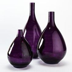 three purple vases sitting next to each other