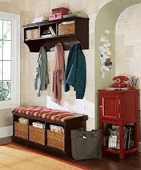 a coat rack with several coats hanging on it next to a red cabinet and window