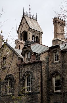 an old brick building with a clock tower on the top and two windows in front