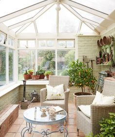 a sun room filled with lots of furniture and potted plants on the side of it