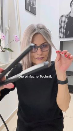 a woman with grey hair and glasses holding scissors