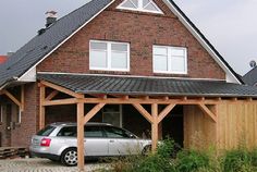 a car is parked in front of a house with a wooden porch and attached roof