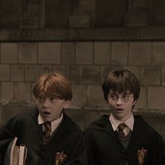 two young boys in harry potter outfits standing next to each other