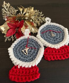 two crocheted christmas ornaments sitting on top of a table next to a poinsettia