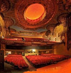 an empty auditorium with red seats and ornate ceiling