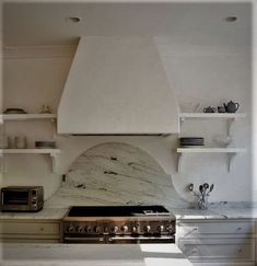 a stove top oven sitting inside of a kitchen next to white cabinets and shelves filled with dishes