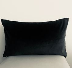 a black pillow sitting on top of a white couch