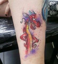 a tattoo on the leg of a person with a colorful horse and swirls design