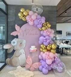 the balloon arch is decorated with pink, purple and gold balloons for a baby's first birthday