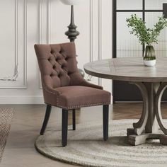 a dining room table with two chairs and a rug