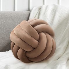 a large knot pillow sitting on top of a couch