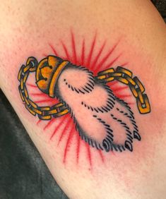 a close up of a person's arm with a tattoo on it and a chain around the arm