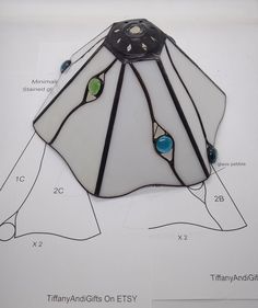 a stained glass lamp hanging from the ceiling on a sheet of paper with instructions for how to make it