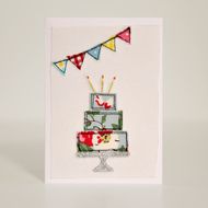 a card with a cake on it and bunting flags hanging from the top, in front of a white background